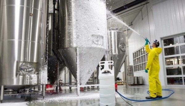 A large tank of liquid is being sprayed with water.