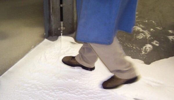 A person walking on the floor of an elevator.