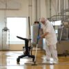 Man cleaning floor with mop and cart.